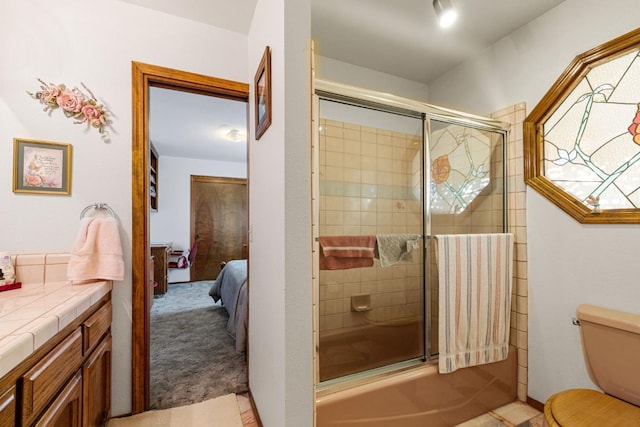 full bathroom with tile patterned flooring, combined bath / shower with glass door, vanity, and toilet