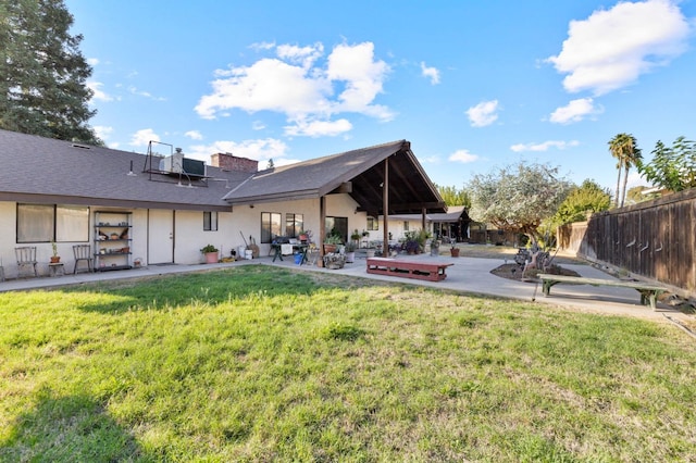 back of property featuring a lawn and a patio