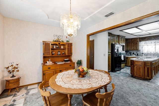 dining space featuring light carpet and a notable chandelier