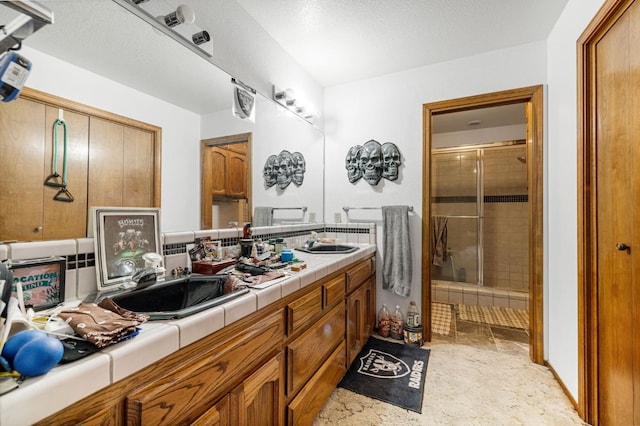 bathroom with walk in shower, a textured ceiling, and vanity