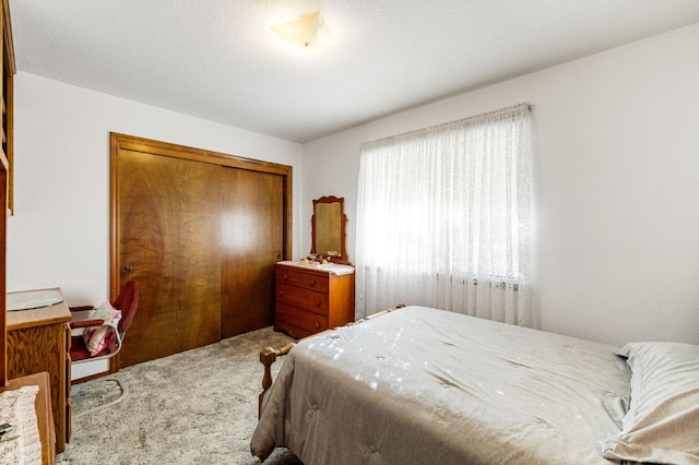 bedroom with light colored carpet and a closet