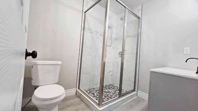 bathroom with vanity, toilet, and a shower with door