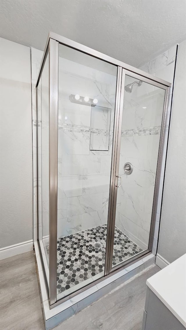 bathroom featuring a shower with door, vanity, and hardwood / wood-style flooring