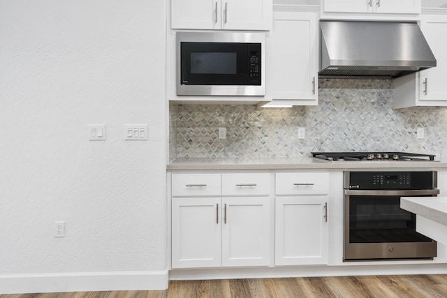 285 S Huckleberry Ln S, S, CA 93636 - kitchen featuring light countertops, wall chimney exhaust hood, appliances with stainless steel finishes, white cabinetry, and backsplash
