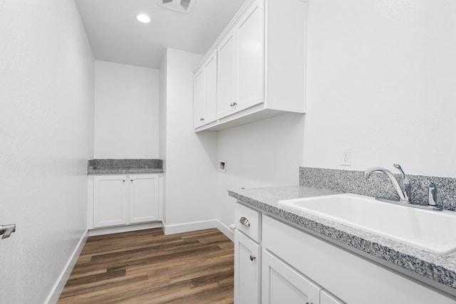 laundry room with cabinet space, baseboards, dark wood-style floors, washer hookup, and a sink