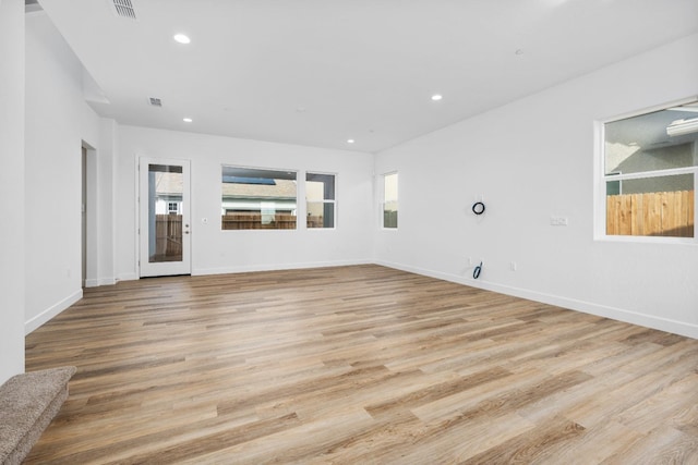 unfurnished living room featuring light wood-style floors, recessed lighting, visible vents, and baseboards