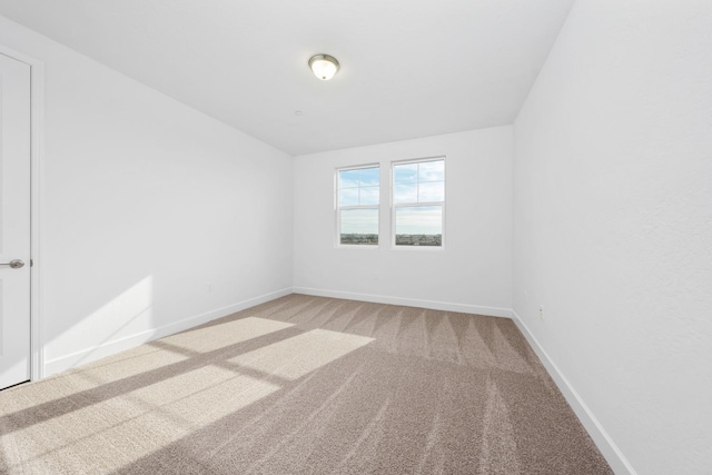 carpeted empty room with baseboards