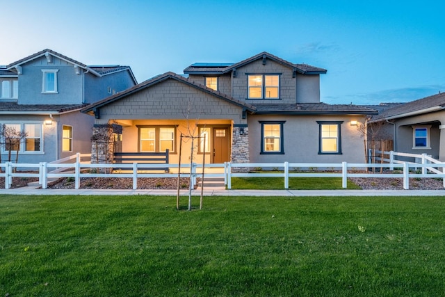 view of front of house with solar panels, a front lawn, and a fenced front yard