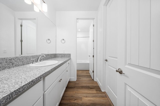 bathroom featuring tub / shower combination, wood finished floors, and vanity