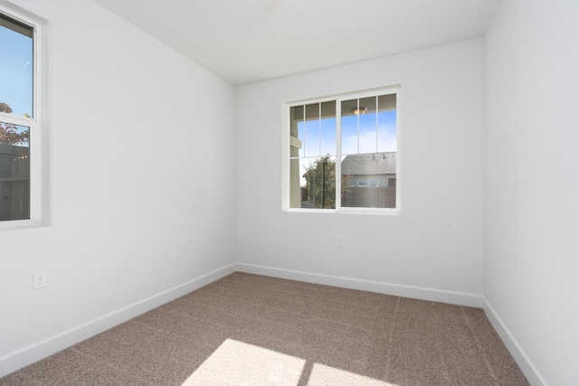 carpeted spare room featuring baseboards