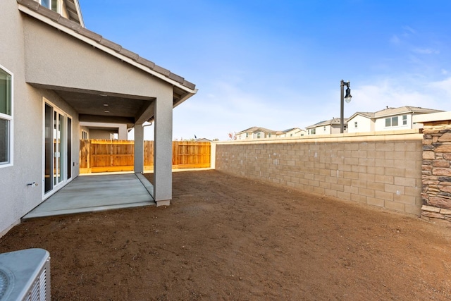 view of yard featuring a patio, central air condition unit, and a fenced backyard