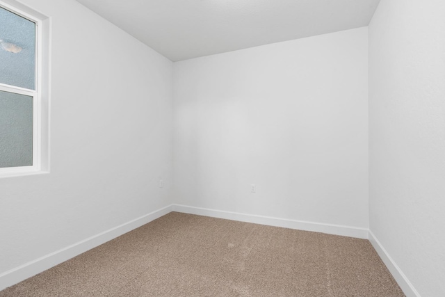 unfurnished room featuring baseboards and carpet