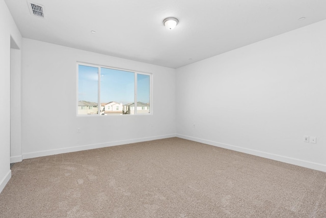 carpeted empty room with visible vents and baseboards