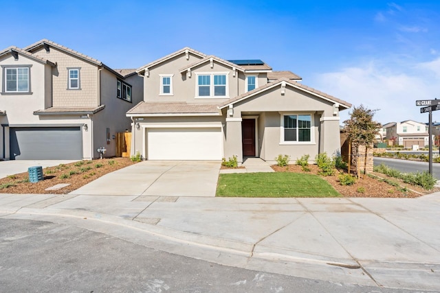 view of front of house featuring an attached garage, stucco siding, concrete driveway, a tile roof, and roof mounted solar panels