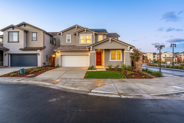 view of front of property with stucco siding, solar panels, concrete driveway, and a garage