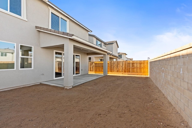 back of property featuring a patio area, stucco siding, and a fenced backyard