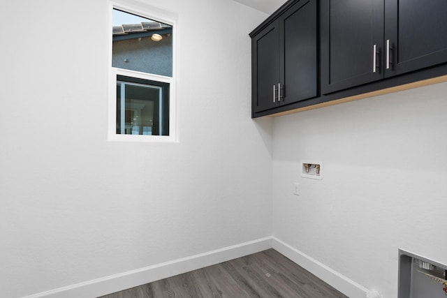 washroom featuring cabinet space, washer hookup, baseboards, and wood finished floors