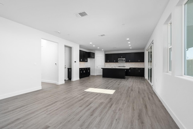 unfurnished living room featuring recessed lighting, visible vents, baseboards, and light wood finished floors