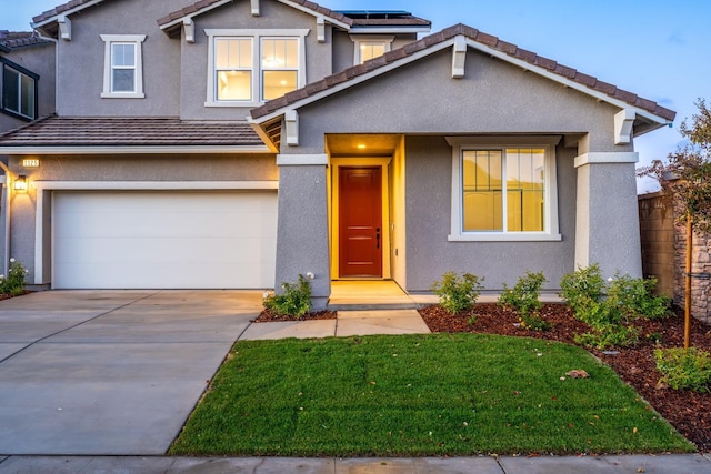 traditional-style house featuring driveway, solar panels, an attached garage, stucco siding, and a tile roof