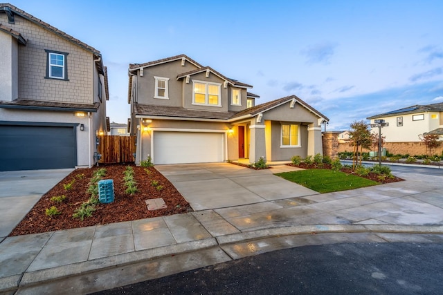 view of front of property featuring stucco siding, a tile roof, fence, concrete driveway, and an attached garage