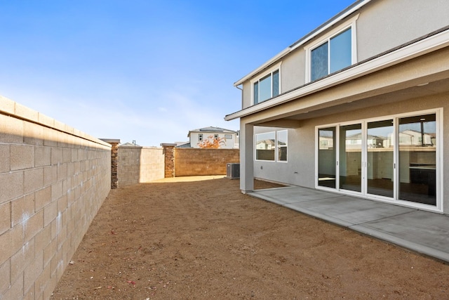 view of yard with cooling unit, a fenced backyard, and a patio