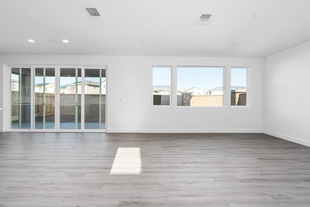 unfurnished room with recessed lighting, wood finished floors, and baseboards