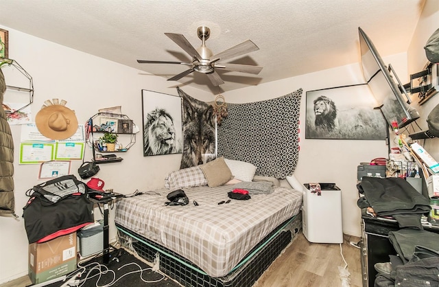 bedroom with light wood-type flooring, a textured ceiling, and ceiling fan