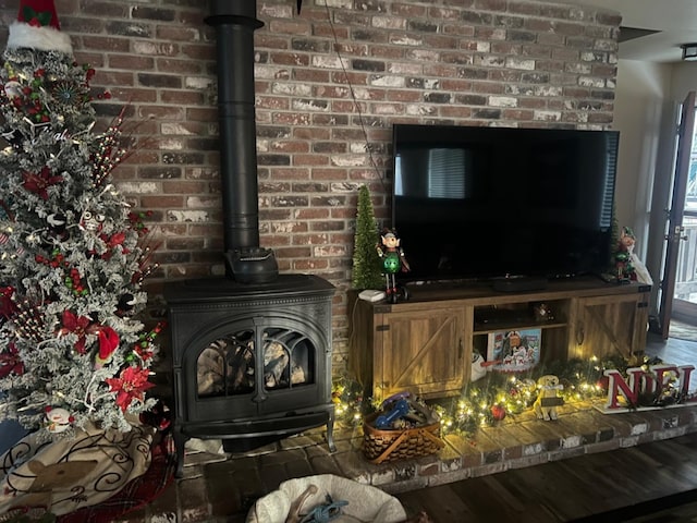 living room featuring brick wall and a wood stove