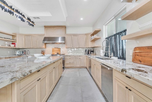 kitchen with light brown cabinetry, stainless steel appliances, exhaust hood, and tasteful backsplash