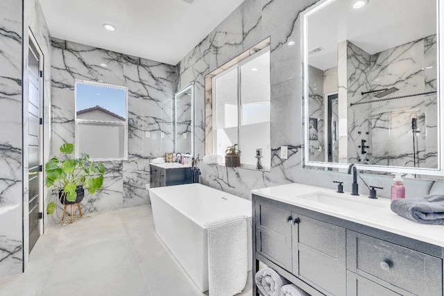 bathroom featuring a bathing tub, vanity, and tile walls