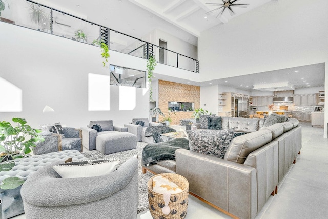 living room featuring a high ceiling, beam ceiling, and ceiling fan