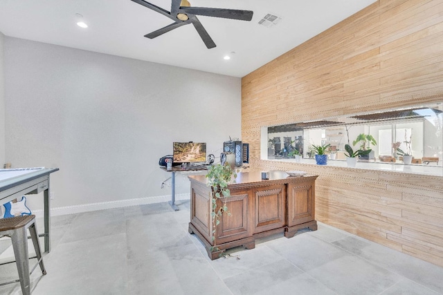 office space with wood walls and ceiling fan