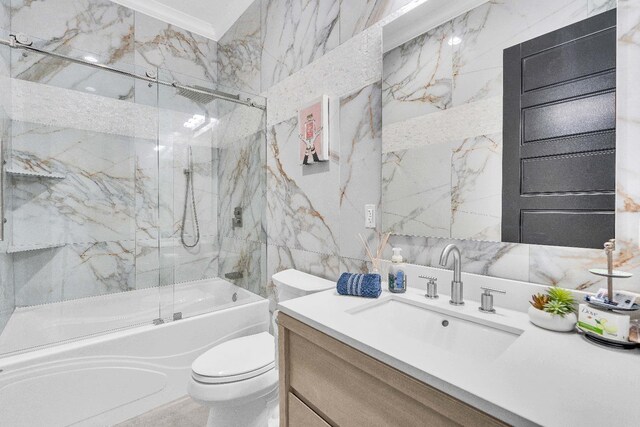 full bathroom featuring tile walls, vanity, enclosed tub / shower combo, crown molding, and toilet