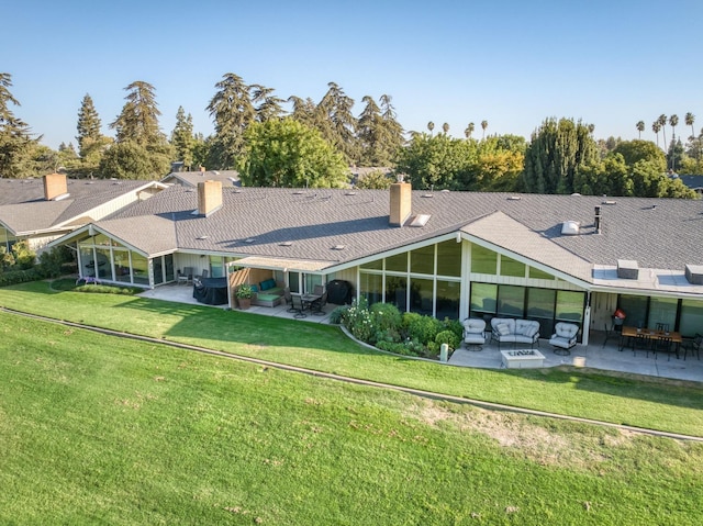 back of property featuring an outdoor living space, a patio, and a lawn