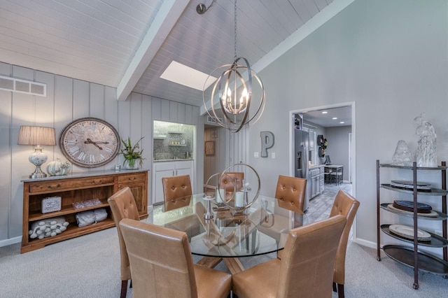 carpeted dining room featuring beam ceiling, a skylight, high vaulted ceiling, and a chandelier