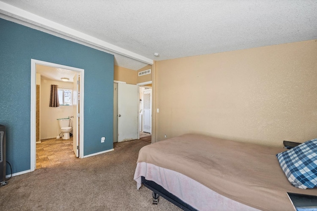 carpeted bedroom featuring a textured ceiling, lofted ceiling, and ensuite bathroom