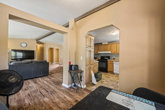 kitchen featuring black range with electric stovetop, a textured ceiling, light hardwood / wood-style flooring, dishwasher, and lofted ceiling with beams