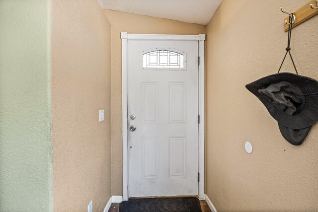 doorway to outside featuring lofted ceiling