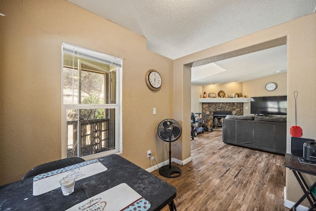 interior space with a textured ceiling, a fireplace, and hardwood / wood-style flooring