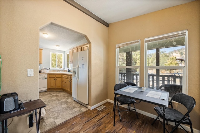 office space featuring a textured ceiling, light hardwood / wood-style floors, and lofted ceiling