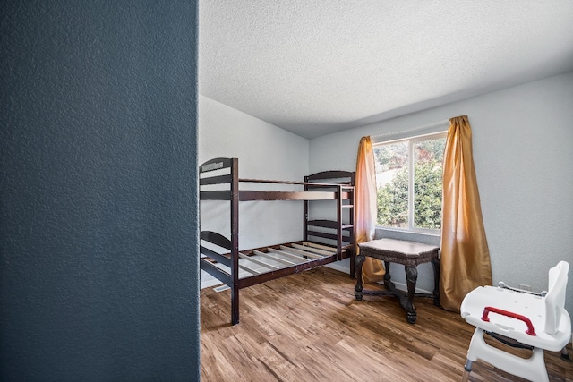 bedroom with hardwood / wood-style flooring and a textured ceiling