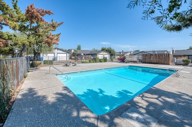 community pool featuring a patio area, fence, and a residential view