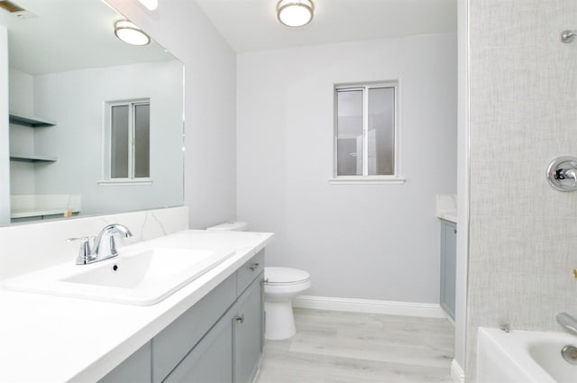 full bathroom featuring hardwood / wood-style floors, shower / bathtub combination, vanity, and toilet