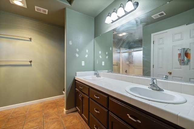 bathroom with vanity, a shower with shower door, toilet, and tile patterned floors