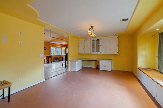 kitchen featuring built in desk and white cabinetry