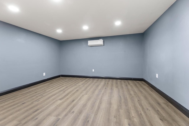 unfurnished room featuring light hardwood / wood-style flooring and a wall unit AC