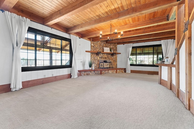 unfurnished living room with beamed ceiling, carpet floors, a notable chandelier, and wood ceiling