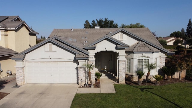 view of front of home with a garage and a front lawn