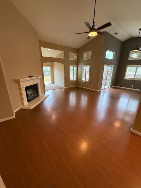 unfurnished living room with hardwood / wood-style flooring, ceiling fan, and lofted ceiling