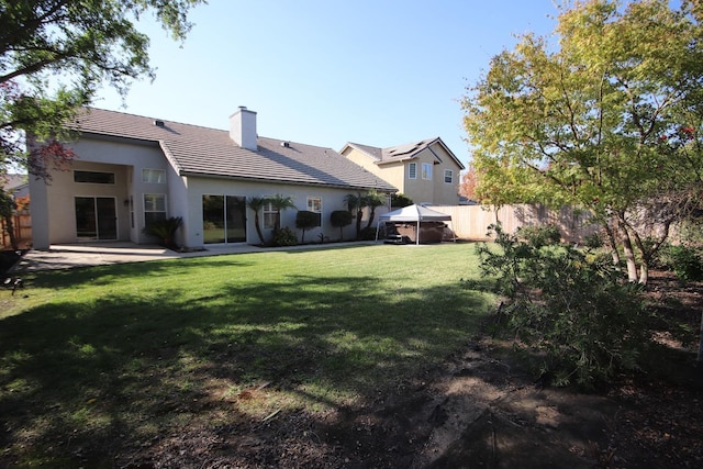 back of property with a gazebo, a patio area, and a yard